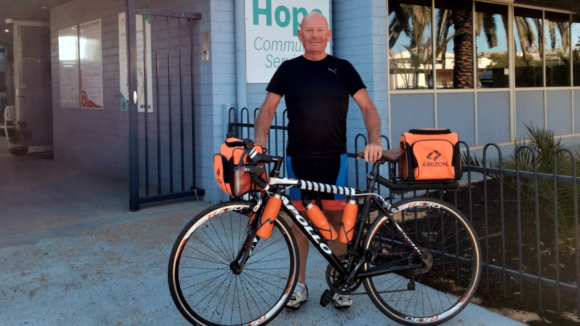 Paul Richardson, a man wearing black cycling gear, stands with his bike.